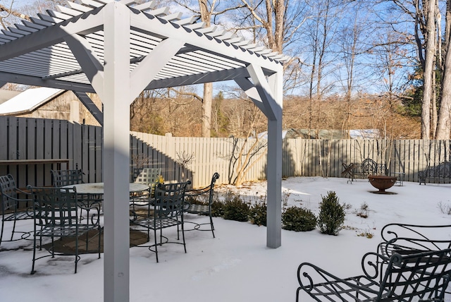 snow covered patio with a pergola