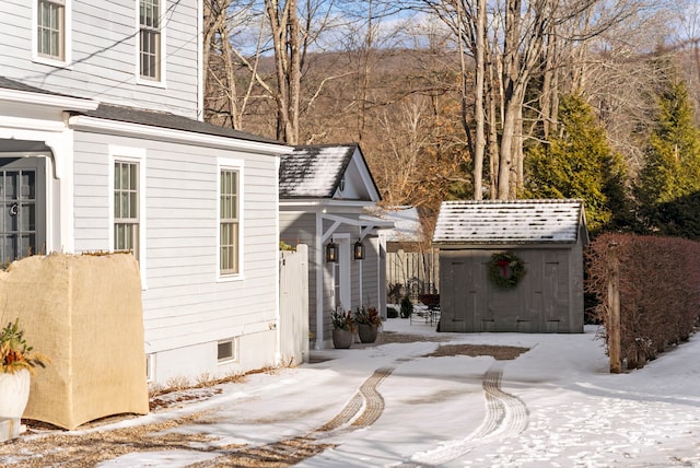 view of snowy exterior featuring a storage shed