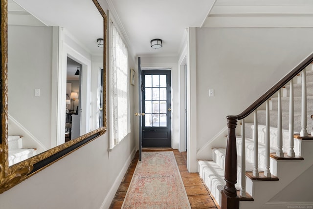 entrance foyer with ornamental molding and light hardwood / wood-style floors