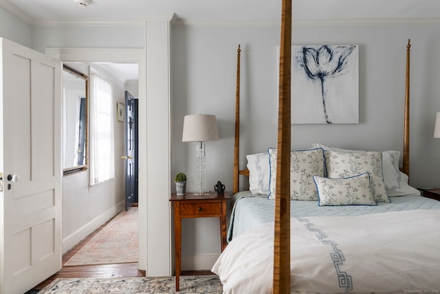 bedroom featuring ornamental molding and light wood-type flooring