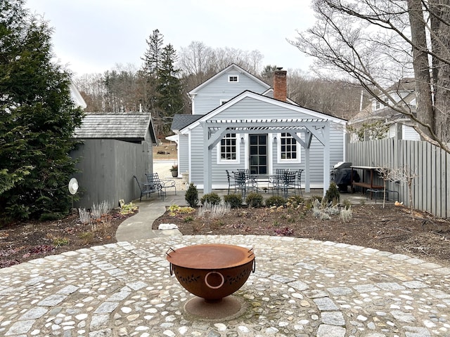 back of property featuring an outdoor fire pit, a patio area, and a shed