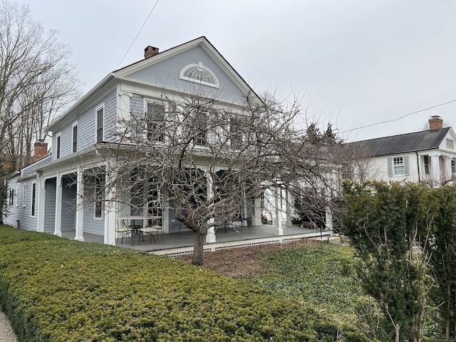 view of side of property with a patio area and a lawn