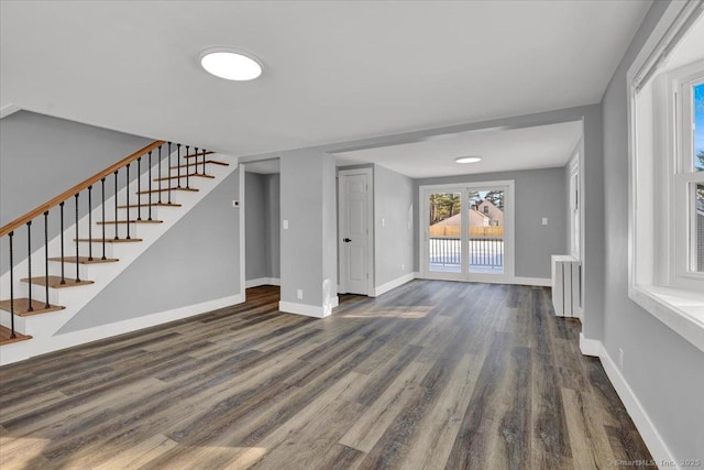 unfurnished living room featuring radiator heating unit and dark hardwood / wood-style floors