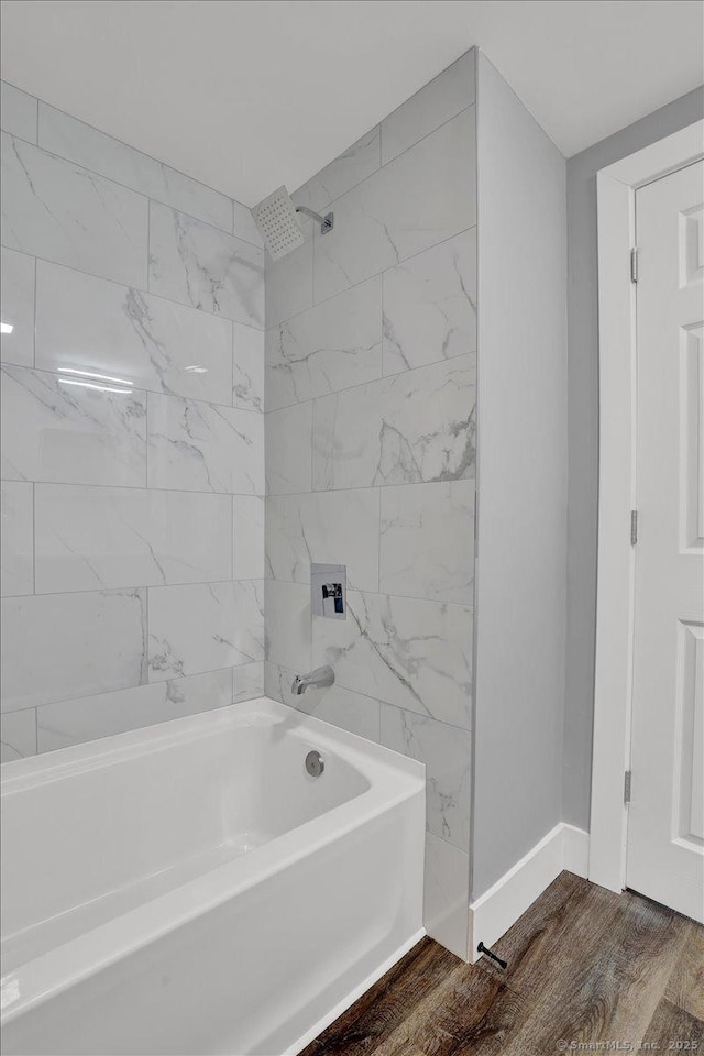 bathroom with tiled shower / bath combo and hardwood / wood-style flooring