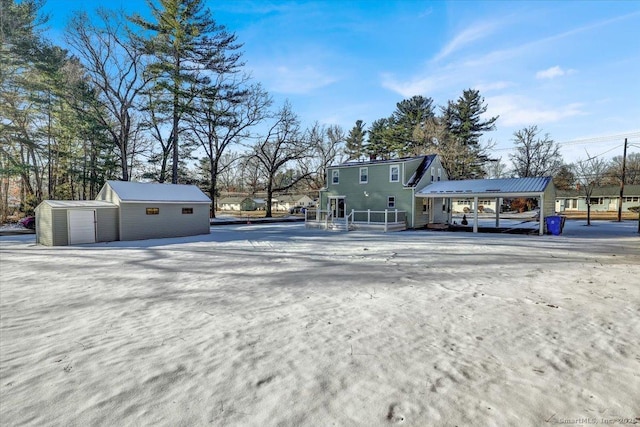 view of front of home with a carport and a storage unit