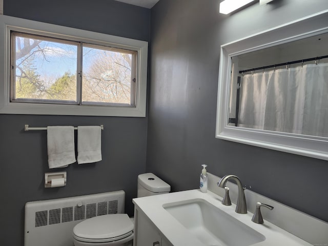 bathroom with vanity, radiator heating unit, and toilet