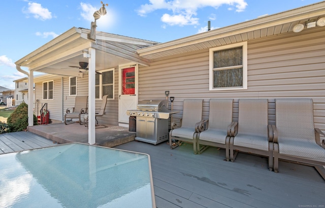 wooden deck with area for grilling and ceiling fan