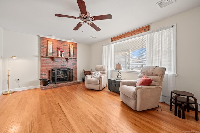 living room with ceiling fan, a fireplace, and hardwood / wood-style floors