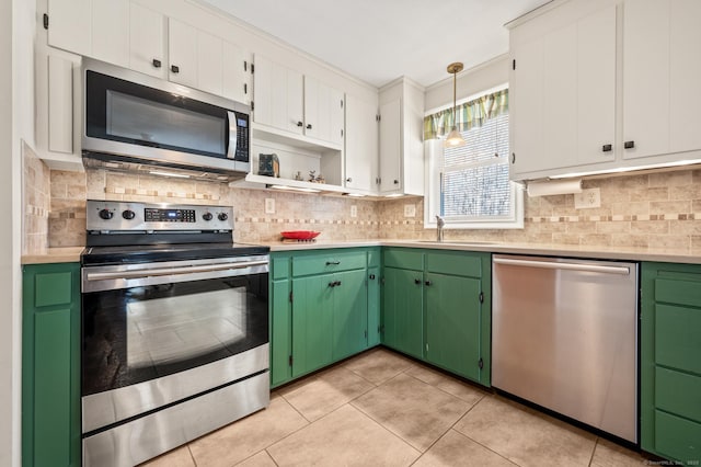 kitchen featuring pendant lighting, sink, white cabinetry, stainless steel appliances, and green cabinetry