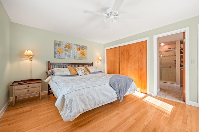 bedroom with ceiling fan, ensuite bath, light wood-type flooring, and a closet