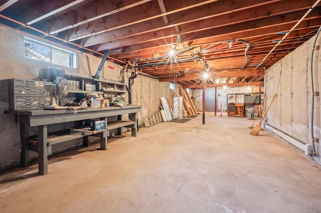 basement featuring a workshop area and baseboard heating