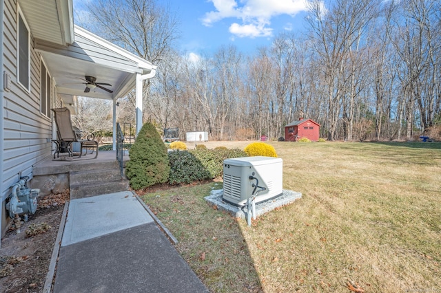 view of yard featuring a patio area, ceiling fan, and a shed