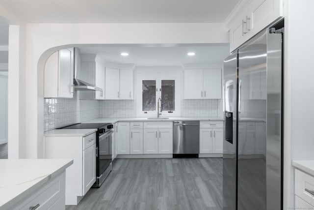 kitchen with white cabinetry, sink, stainless steel appliances, and light hardwood / wood-style floors