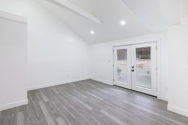 unfurnished room with vaulted ceiling, light hardwood / wood-style floors, and french doors