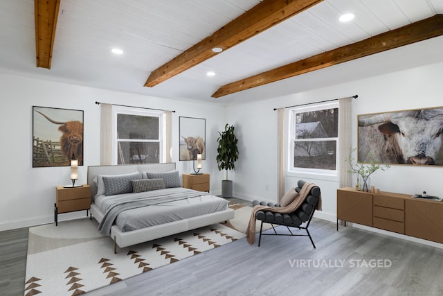 bedroom with hardwood / wood-style floors and beamed ceiling