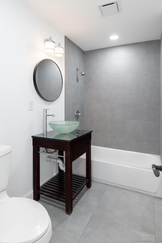 full bathroom with sink, tiled shower / bath, tile patterned floors, and toilet