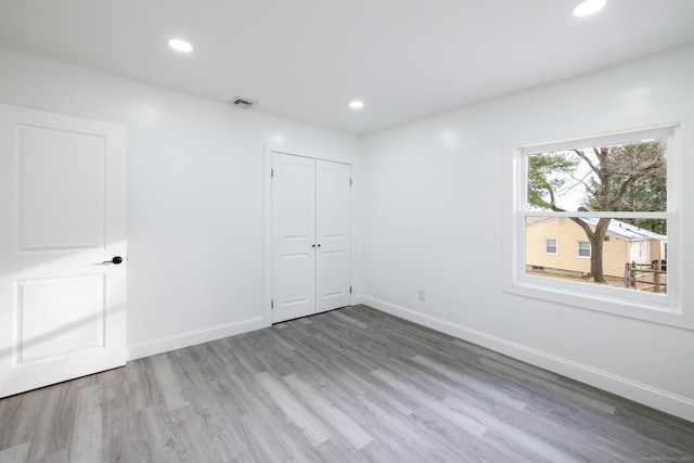 unfurnished bedroom featuring light hardwood / wood-style floors and a closet