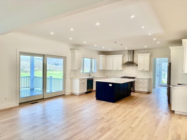 kitchen with white cabinetry, backsplash, a center island, black appliances, and wall chimney exhaust hood