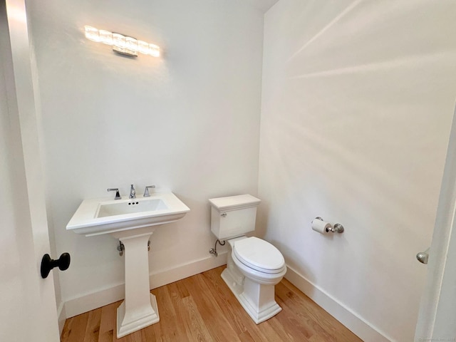 bathroom with hardwood / wood-style floors and toilet