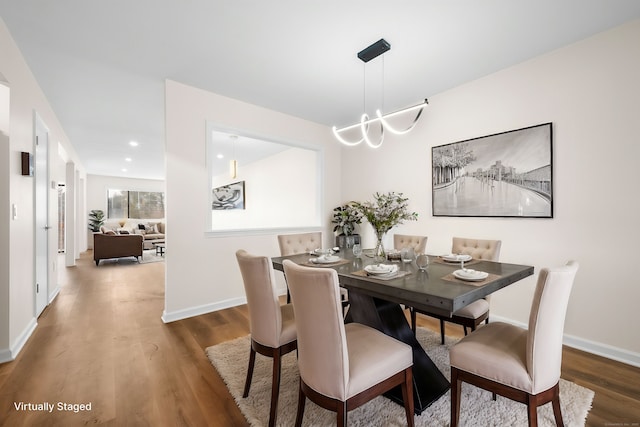 dining area with wood-type flooring and a chandelier