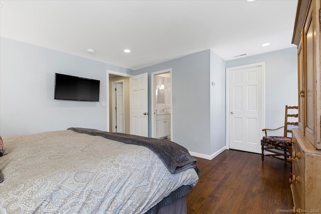 bedroom featuring connected bathroom and dark hardwood / wood-style floors