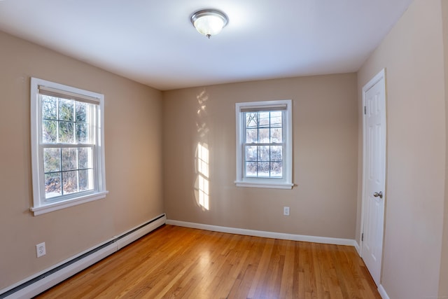 spare room with light wood-type flooring and baseboard heating