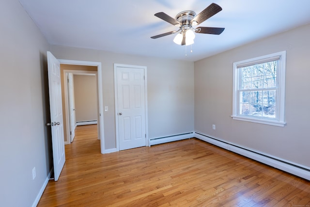 unfurnished bedroom with light hardwood / wood-style flooring, ceiling fan, and baseboard heating