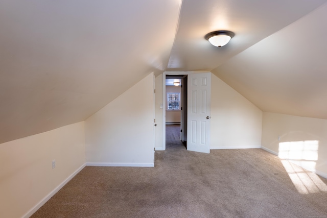 additional living space with carpet flooring and vaulted ceiling