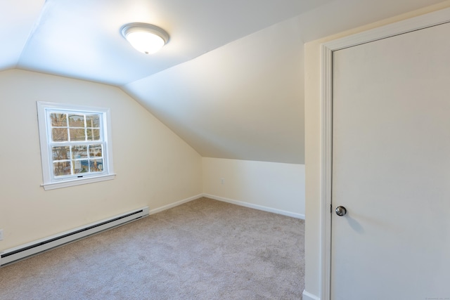 additional living space with vaulted ceiling, a baseboard radiator, and light colored carpet