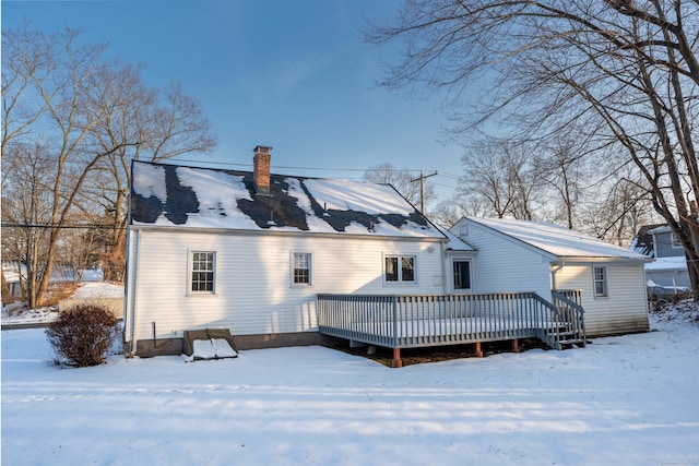 snow covered house with a wooden deck