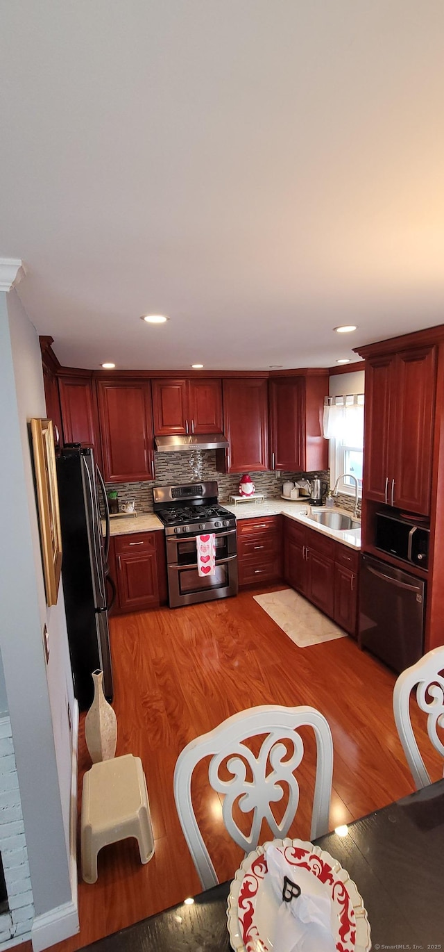 30 Grove Pl, Danbury, CT 06810 - kitchen featuring appliances with stainless steel finishes, reddish brown cabinets, light countertops, light wood-style flooring, and recessed lighting