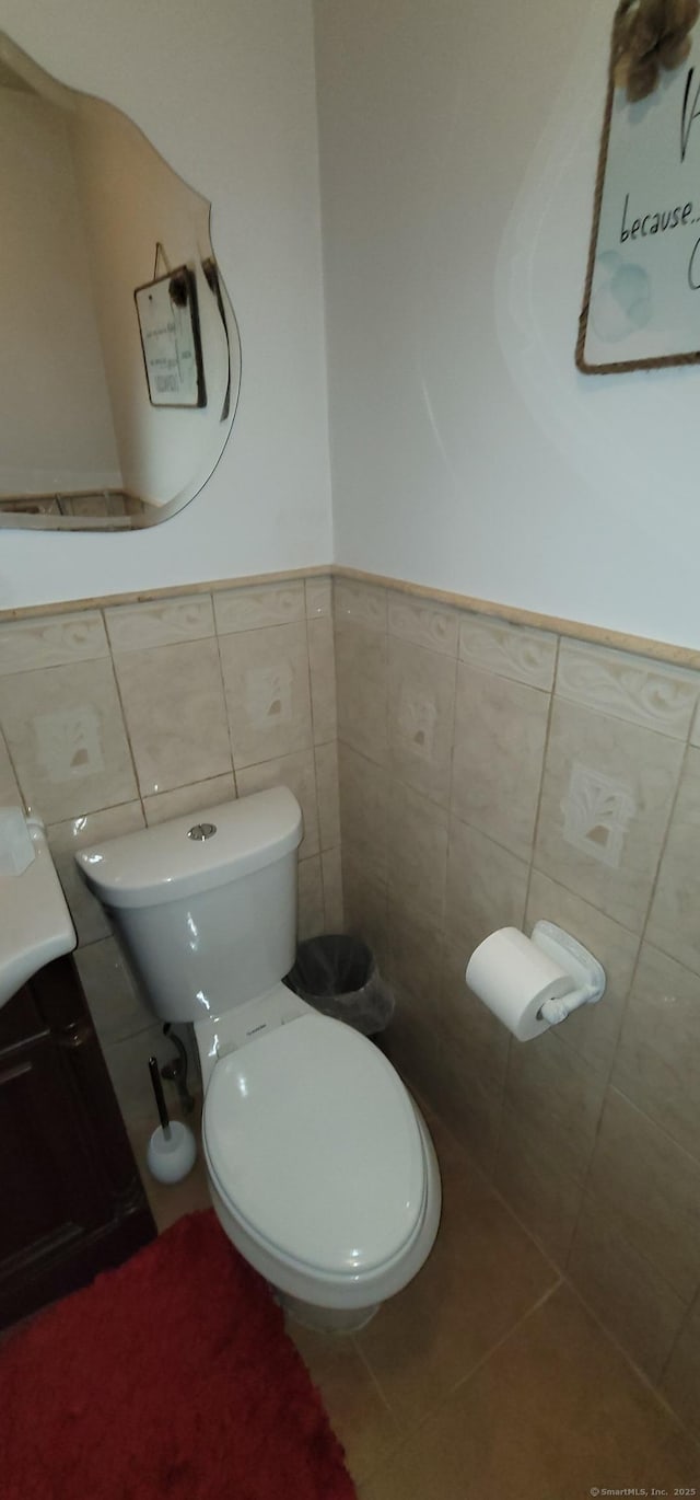 30 Grove Pl, Danbury, CT 06810 - half bathroom featuring tile walls, vanity, a wainscoted wall, and tile patterned flooring