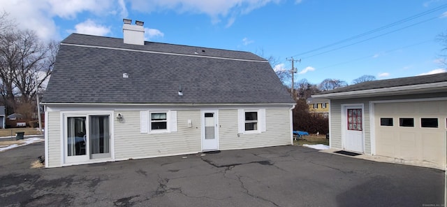 back of property featuring a garage and an outdoor structure