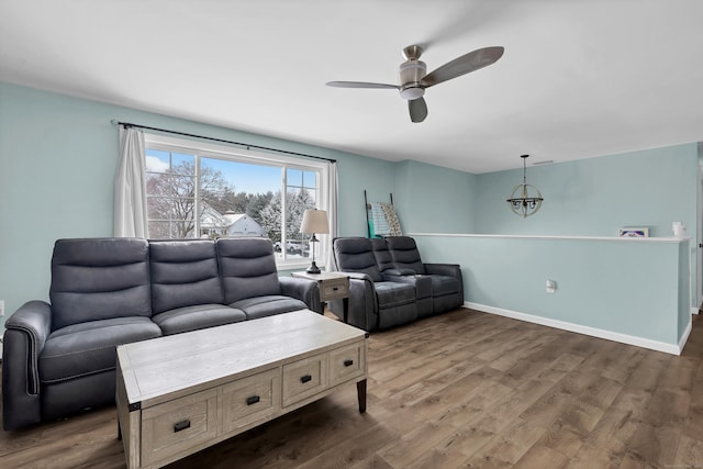 living room featuring dark hardwood / wood-style floors and ceiling fan with notable chandelier