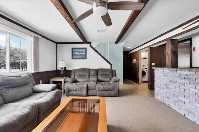 carpeted living room featuring washer / clothes dryer, a textured ceiling, beamed ceiling, and ceiling fan