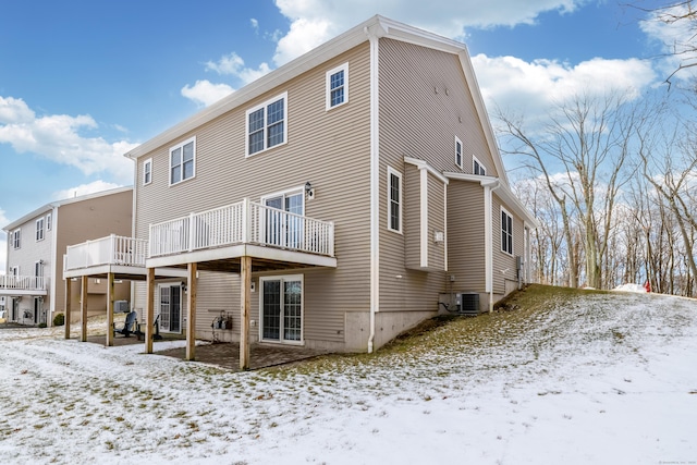 snow covered back of property featuring a wooden deck and central air condition unit