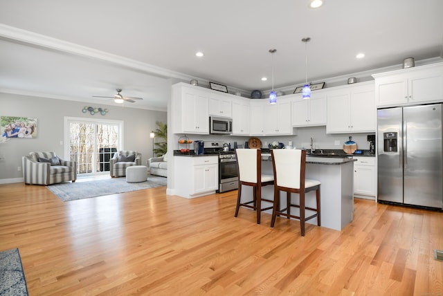 kitchen with white cabinetry, hanging light fixtures, and appliances with stainless steel finishes