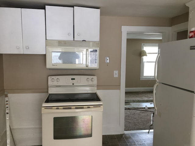 kitchen featuring white cabinetry, dark carpet, and white appliances