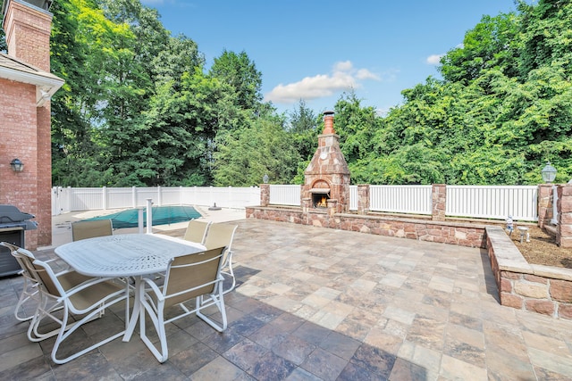 24 Brierwood Dr, Orange, CT 06477 - view of patio with an outdoor stone fireplace, fence, grilling area, and outdoor dining area