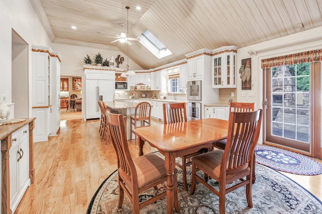 dining space featuring wood ceiling, light wood-type flooring, ornamental molding, ceiling fan, and vaulted ceiling with skylight