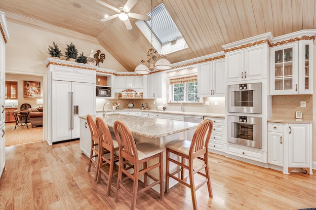 kitchen featuring double oven, a kitchen island with sink, paneled built in fridge, light hardwood / wood-style floors, and wooden ceiling