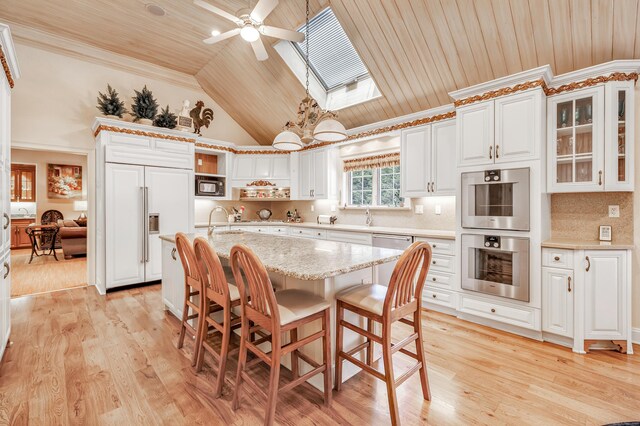 24 Brierwood Dr, Orange, CT 06477 - kitchen with built in appliances, wood ceiling, a skylight, ceiling fan, and glass insert cabinets