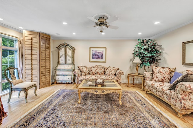 living room with crown molding, ceiling fan, and light hardwood / wood-style floors