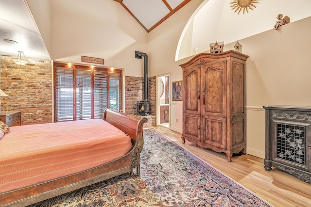 24 Brierwood Dr, Orange, CT 06477 - bedroom featuring a wood stove, light wood-style flooring, high vaulted ceiling, and a wainscoted wall