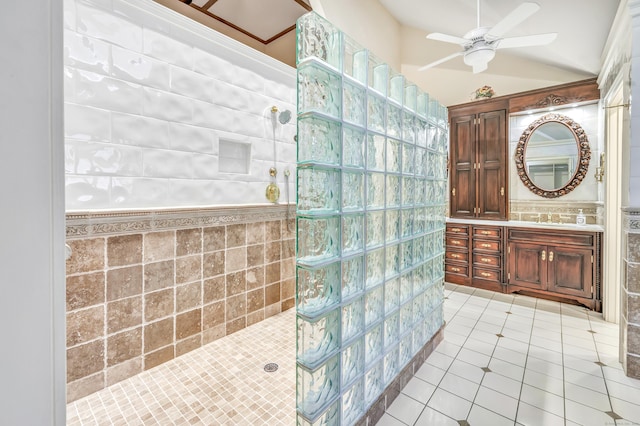 bathroom featuring tiled shower, lofted ceiling, tile patterned flooring, and tile walls