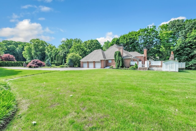 24 Brierwood Dr, Orange, CT 06477 - view of front of home featuring a garage, driveway, a front yard, a shed, and an outbuilding