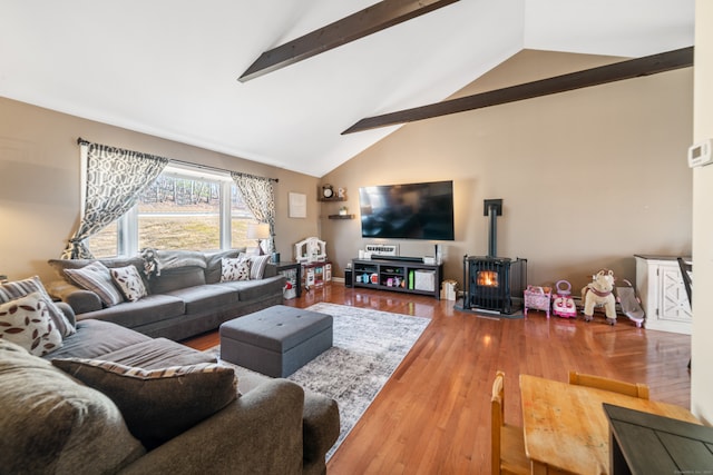 living room featuring hardwood / wood-style flooring, beamed ceiling, high vaulted ceiling, and a wood stove