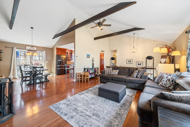 living room with beamed ceiling, dark wood-type flooring, ceiling fan with notable chandelier, and high vaulted ceiling