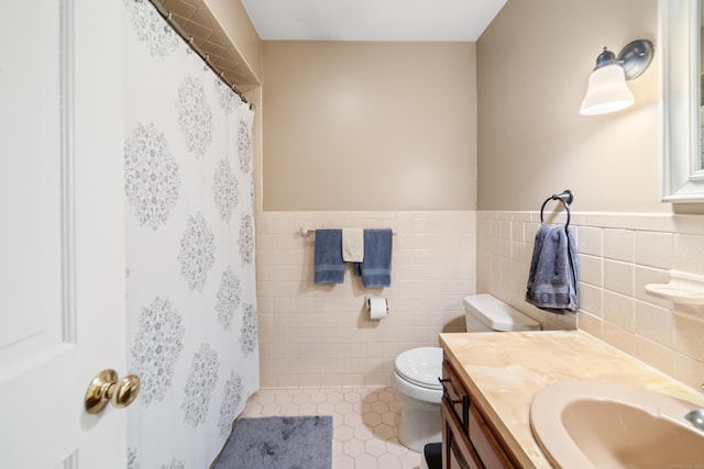 bathroom featuring curtained shower, tile walls, vanity, toilet, and tile patterned floors