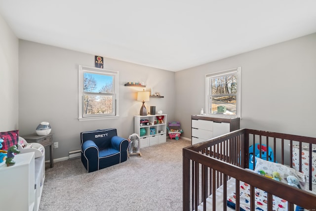 carpeted bedroom featuring multiple windows, a nursery area, and a baseboard heating unit